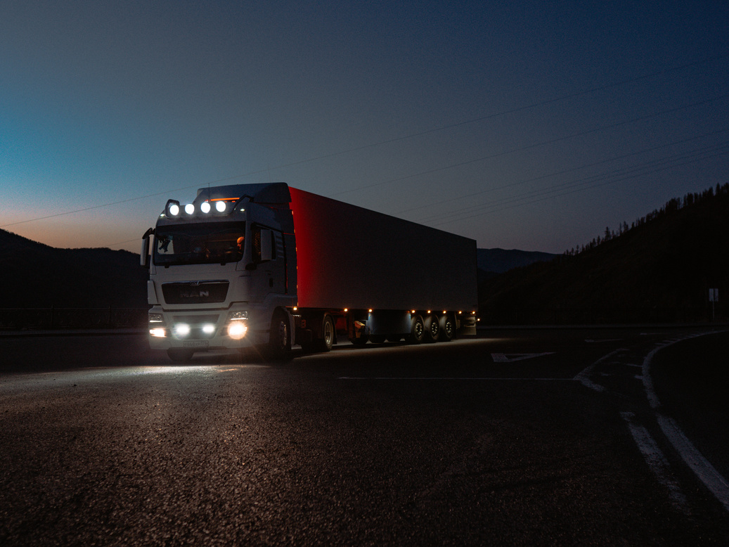 Red and White Freight Truck on Road during Night Time